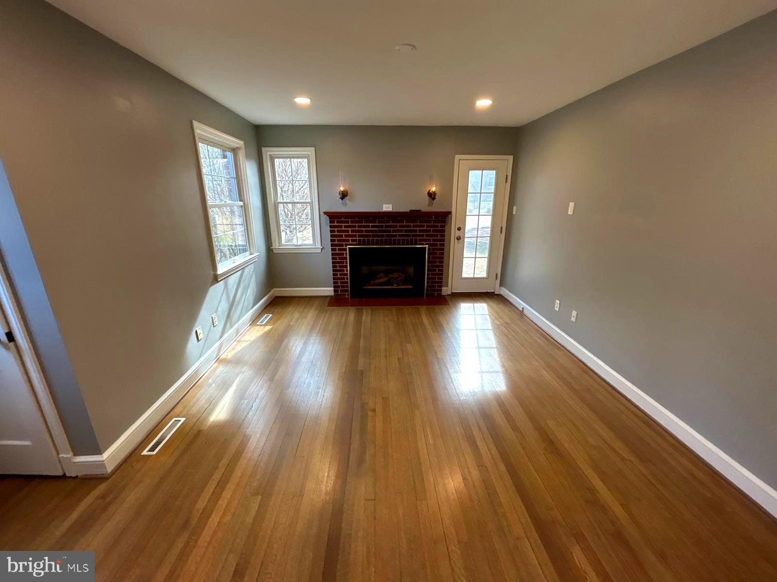4630 Muncaster Mill Road Rockville, MD 20853 - Photo 6 of 40 a view of an empty room with wooden floor fireplace and a window