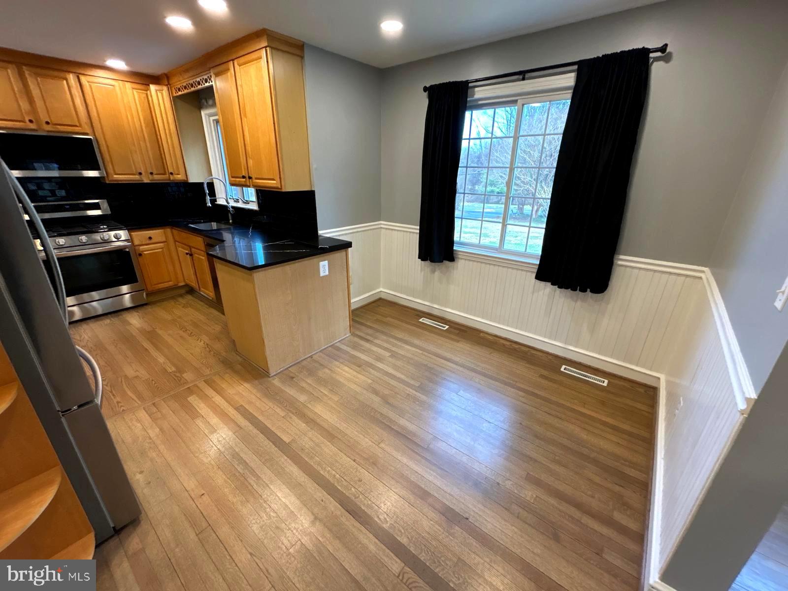 4630 Muncaster Mill Road Rockville, MD 20853 - Photo 10 of 40 a view of a kitchen with kitchen island granite countertop a stove top oven a sink with wooden floors