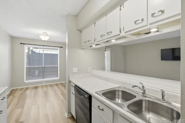 a kitchen with a sink and a white cabinets