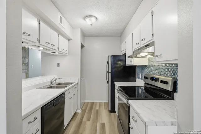 a kitchen with stainless steel appliances a stove sink and refrigerator