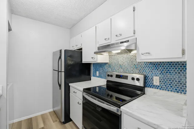 a kitchen with a stove and a refrigerator