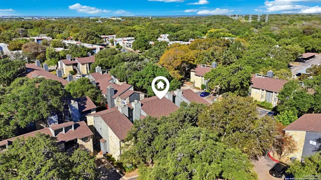 an aerial view of residential houses with outdoor space and trees
