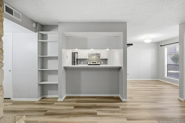 a view of hall way with wooden floor and cabinet
