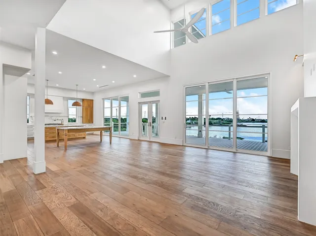 a view of empty room with wooden floor and floor to ceiling window