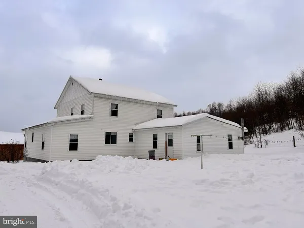 a view of a white house with a wooden fence