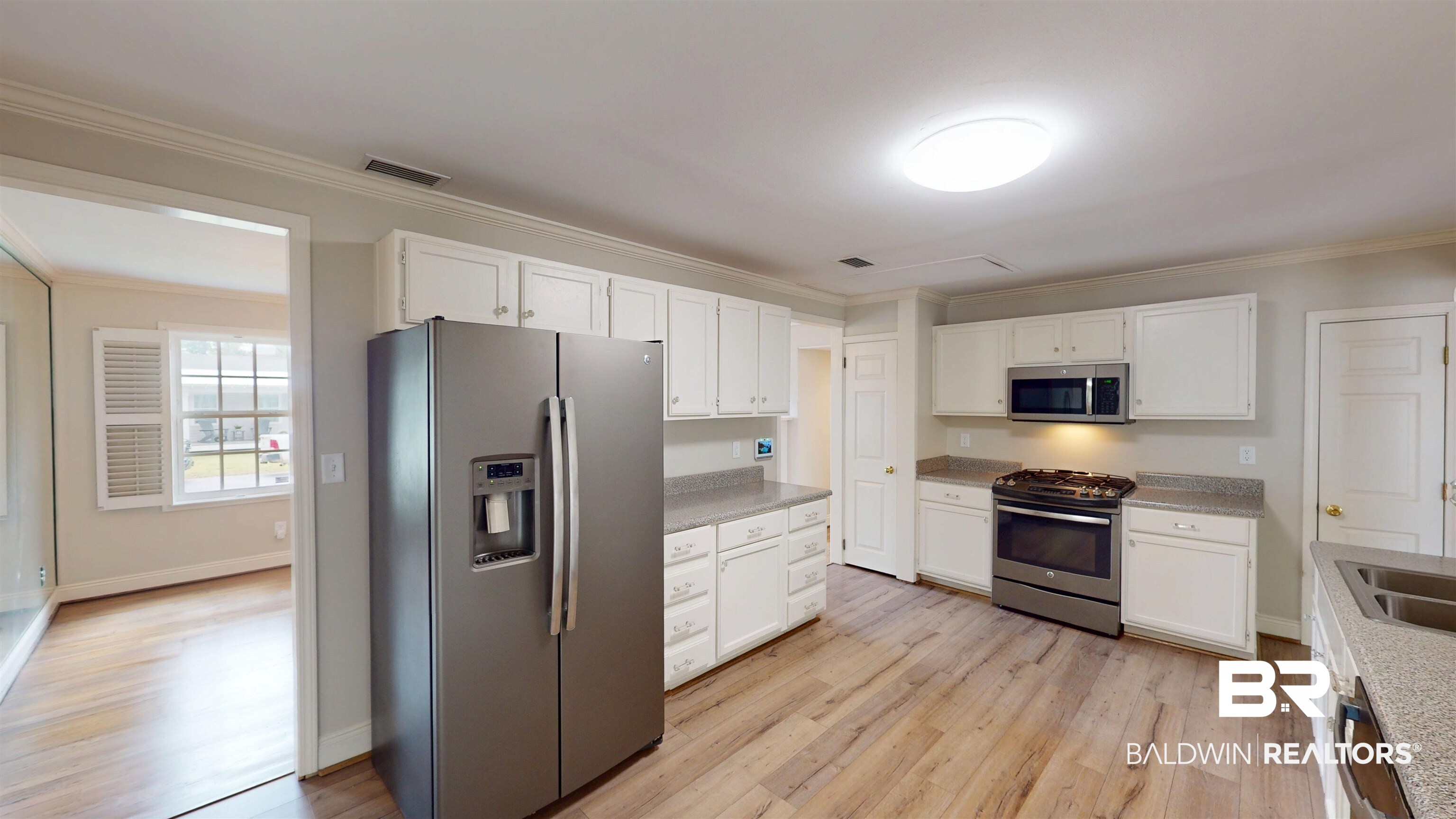 8 Lancaster Road Mobile, AL 36608 - Photo 7 of 24 Kitchen featuring stainless steel appliances, ornamental molding, white cabinets, and light wood-type flooring