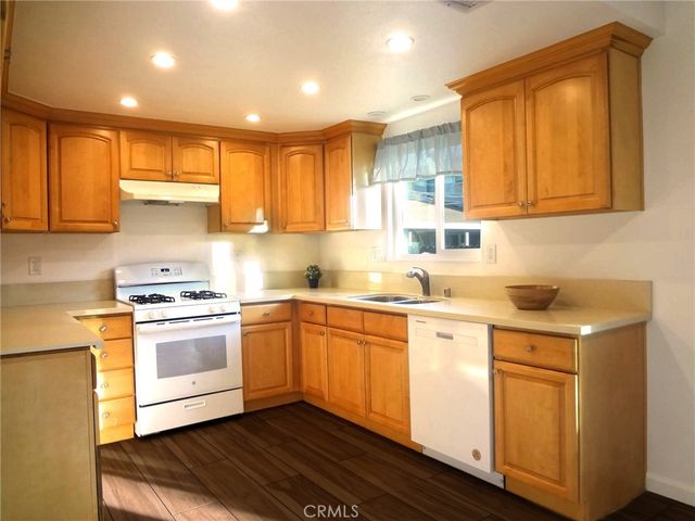 a kitchen with granite countertop white cabinets and white appliances