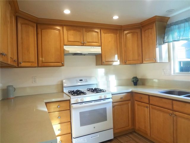 a kitchen with stainless steel appliances granite countertop a sink stove and cabinets