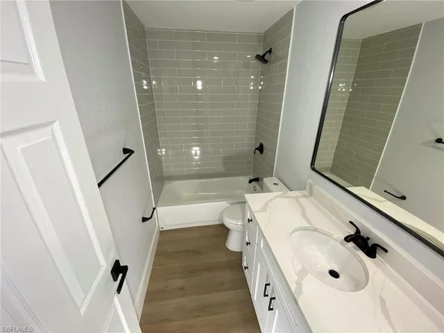 a bathroom with a tub sink and mirror