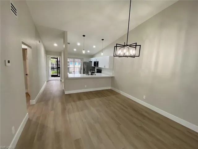 a view of a kitchen with a sink and wooden floor