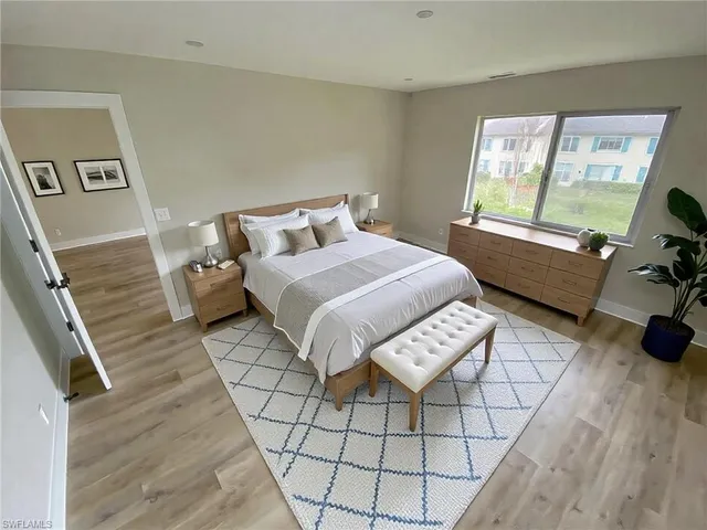 a bed sitting in a bedroom next to a window