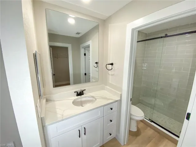 a bathroom with a sink a toilet and shower