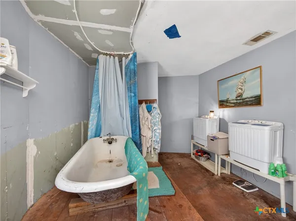 a backyard of a house with a table and chairs under an umbrella