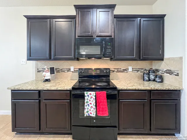 a kitchen with granite countertop a sink stainless steel appliances and cabinets