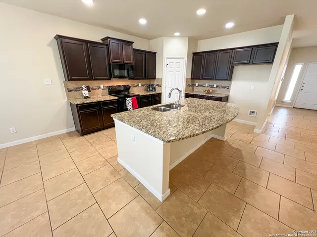 a kitchen with stainless steel appliances a sink a stove a microwave a counter top space and cabinets