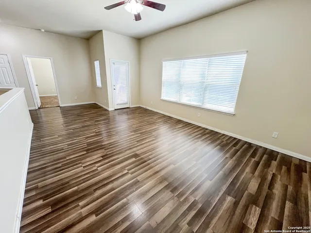a view of an empty room with wooden floor