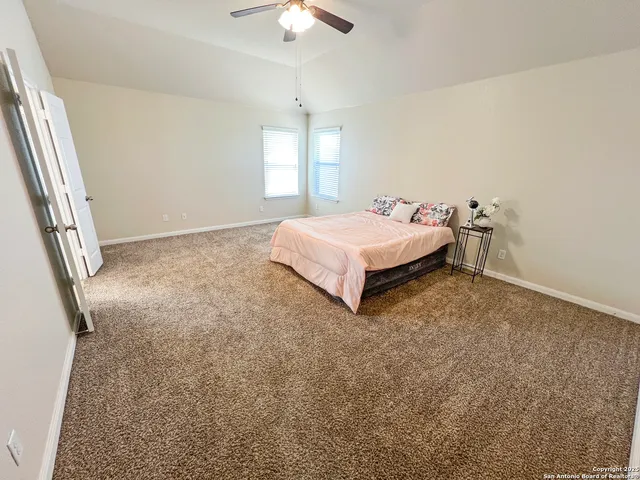 a spacious bedroom with a bed and a window