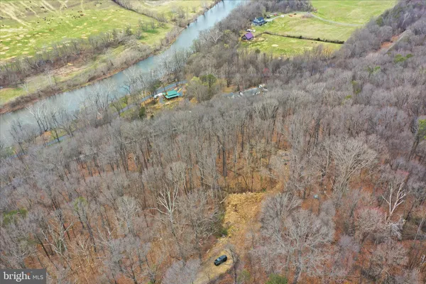 a view of a dry field with mountains in the background