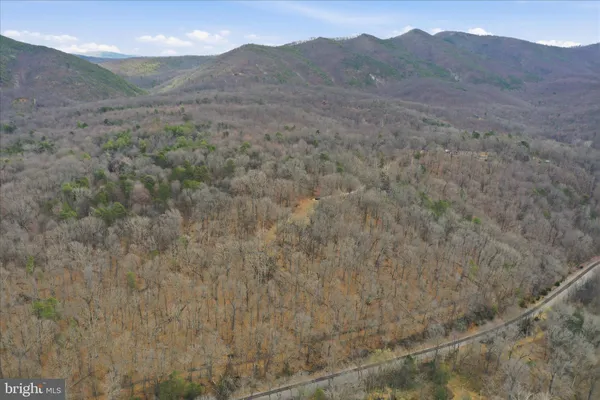 a view of a dry yard with mountains in the background