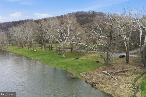a backyard of a house with lots of green space and lake view