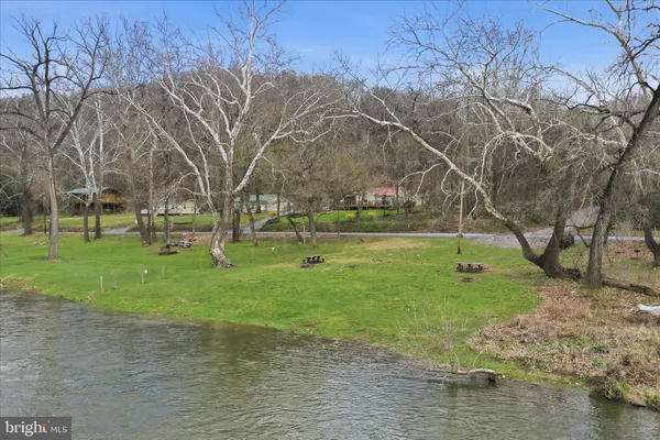 a backyard of a house with lots of green space and lake view