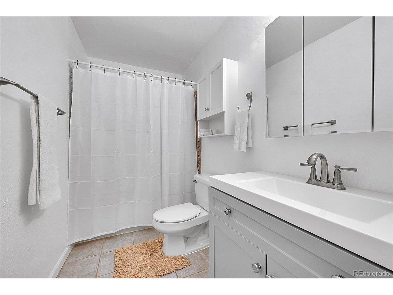 Undisclosed Address Wheat Ridge, CO 80033 - Photo 13 of 21 a bathroom with a sink toilet a mirror and shower