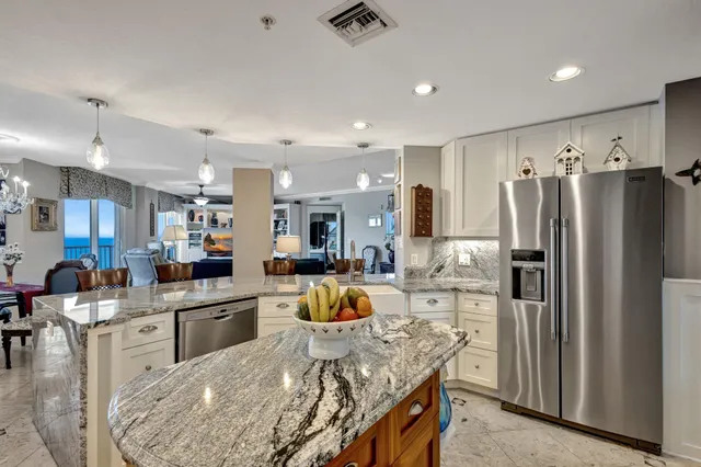 a kitchen with stainless steel appliances granite countertop a sink refrigerator and cabinets
