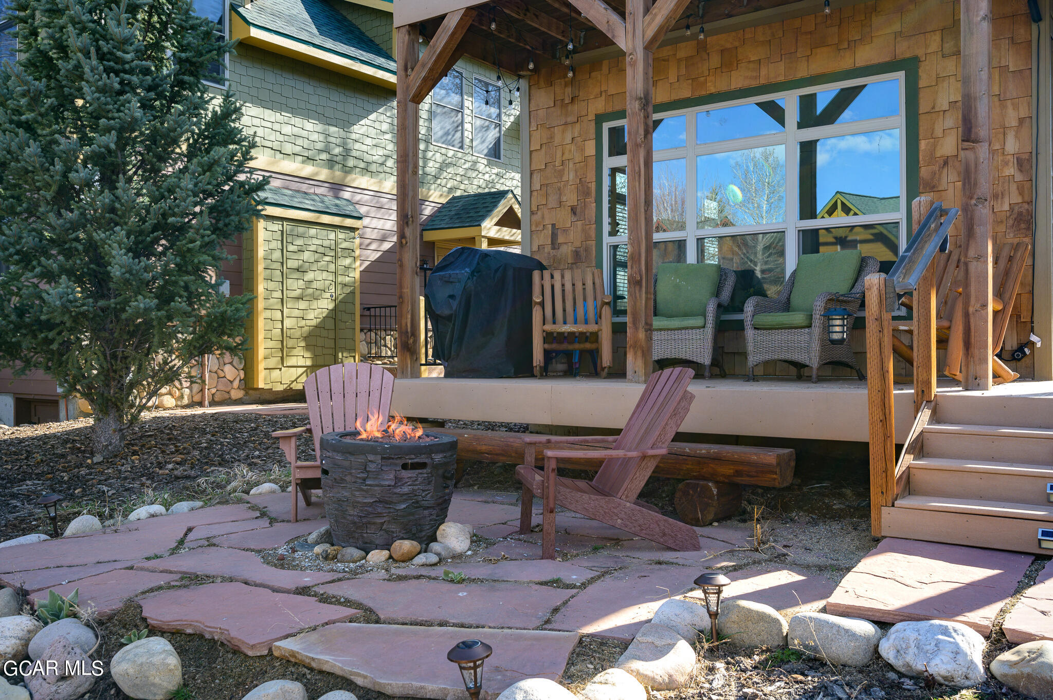 107 Edgewater Circle Granby, CO 80446 - Photo 20 of 51 a view of a patio with table and chairs potted plants and large tree