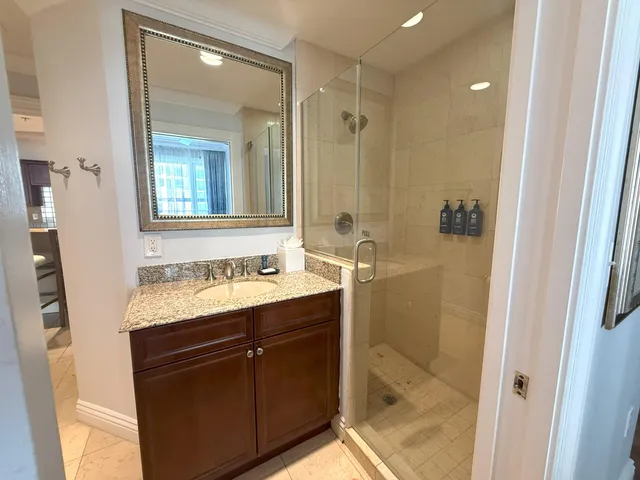 a bathroom with a granite countertop sink toilet and shower