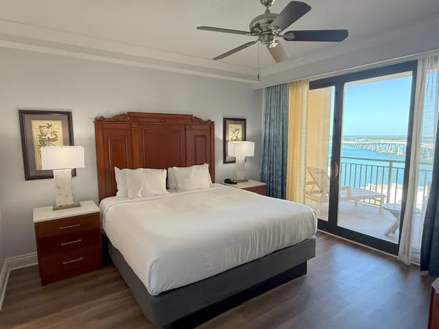 a bedroom with a large bed and a chandelier fan