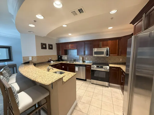 a large kitchen with stainless steel appliances granite countertop a stove and a refrigerator