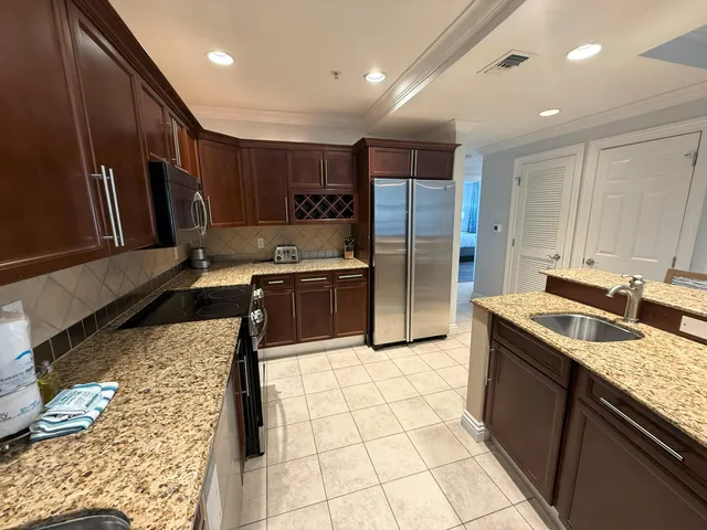 a kitchen with stainless steel appliances granite countertop a sink stove and refrigerator