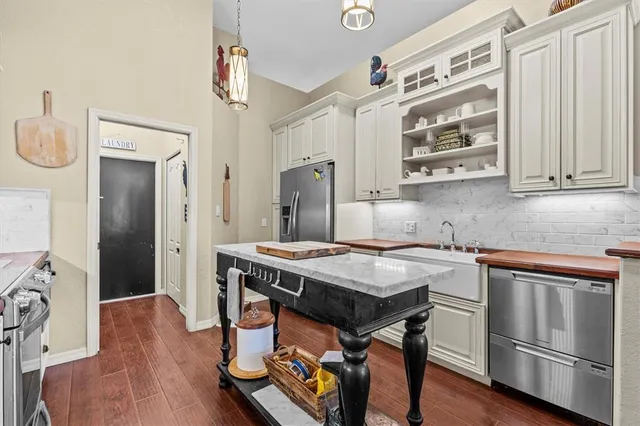 a kitchen with stainless steel appliances granite countertop a stove a refrigerator and a wooden cabinets