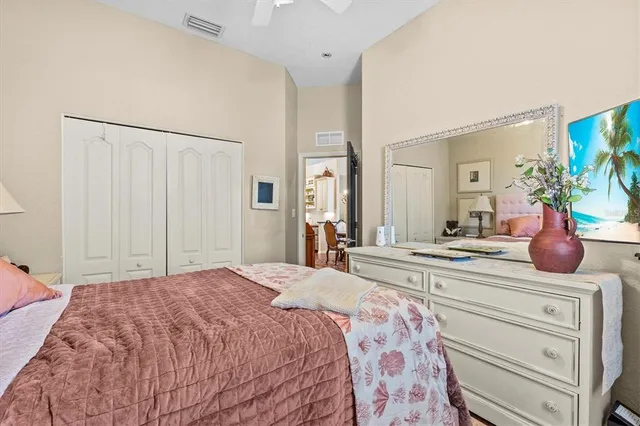 a bedroom with a bed and a lamp on dresser