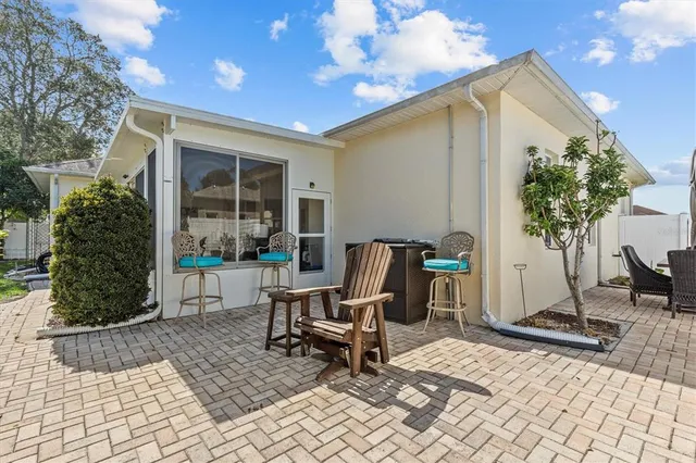 a view of a patio with table and chairs with wooden floor and fence