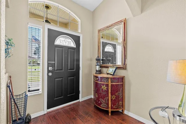 a view of a hallway with entryway wooden floor and front door