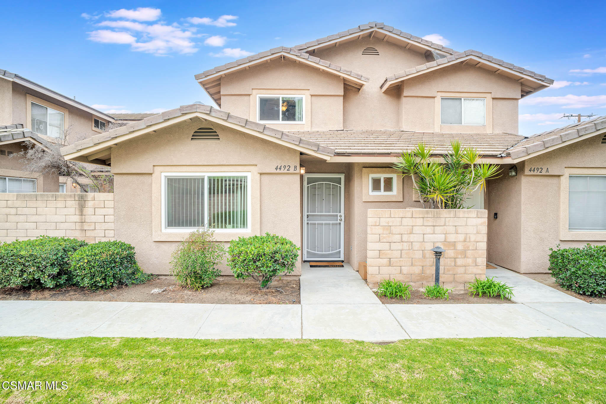 4492 Apricot Road, Unit B Simi Valley, CA 93063 - Photo 2 of 28 a front view of a house with a yard and garage