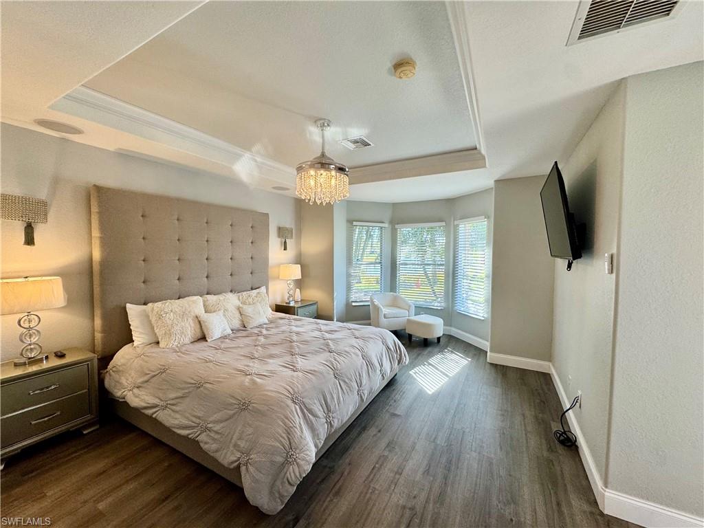 9079 Astonia Way Estero, FL 33967 - Photo 14 of 37 a spacious bedroom with a bed and a flat screen tv