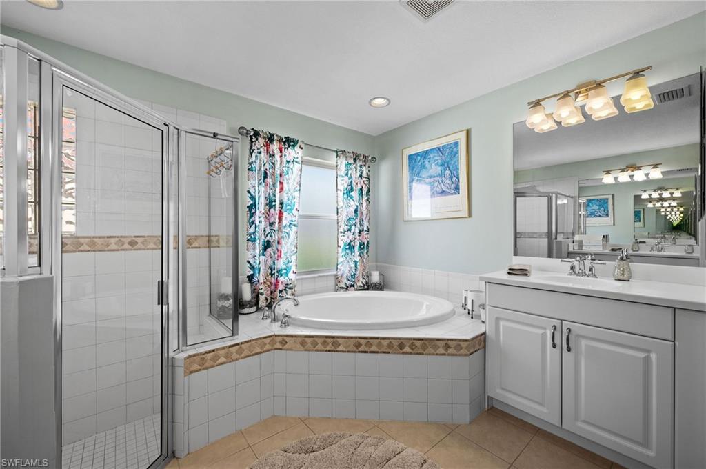 9079 Astonia Way Estero, FL 33967 - Photo 16 of 37 a bathroom with a tub sink and mirror