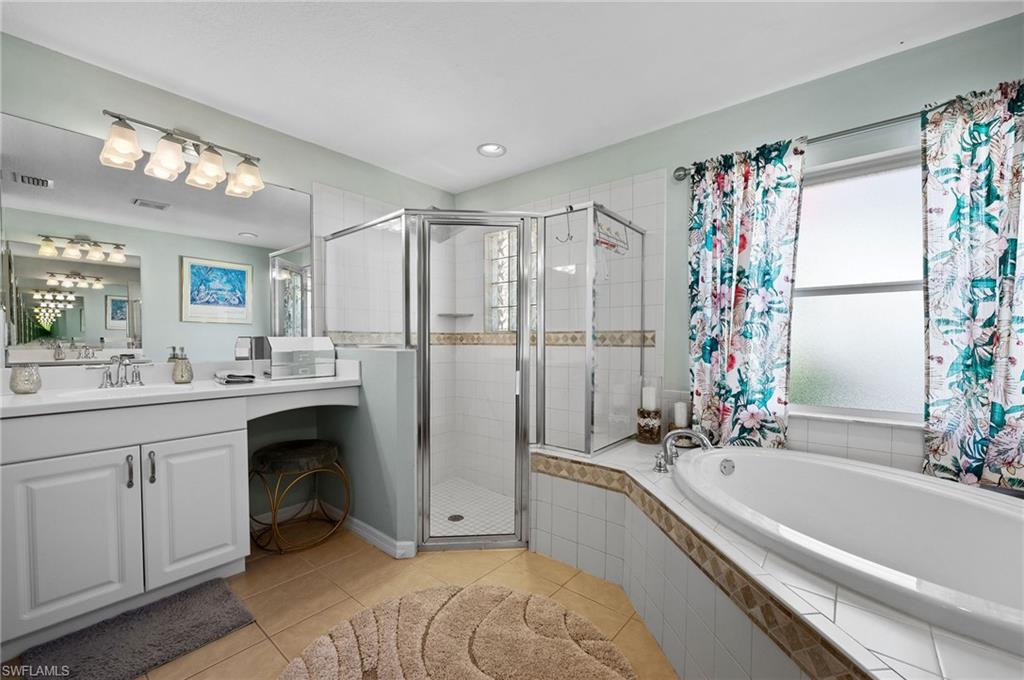 9079 Astonia Way Estero, FL 33967 - Photo 17 of 37 a bathroom with a granite countertop sink a mirror a bathtub and shower