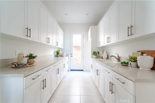 a kitchen with granite countertop lots of white cabinets and white appliances