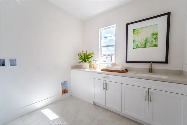 a bathroom with a granite countertop sink and a window