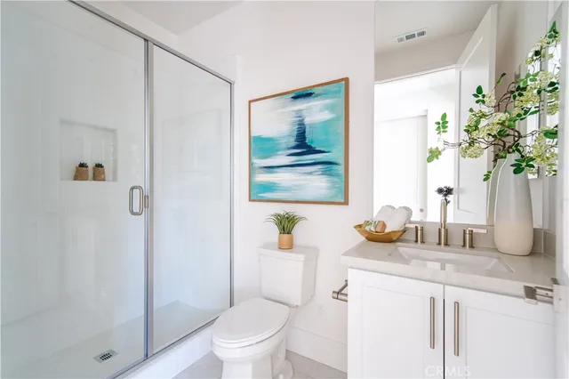 a bathroom with a granite countertop sink a toilet and shower
