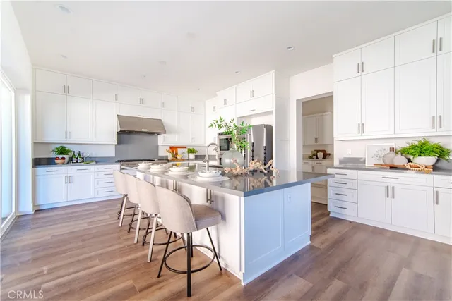 a kitchen with kitchen island granite countertop wooden floors and white stainless steel appliances
