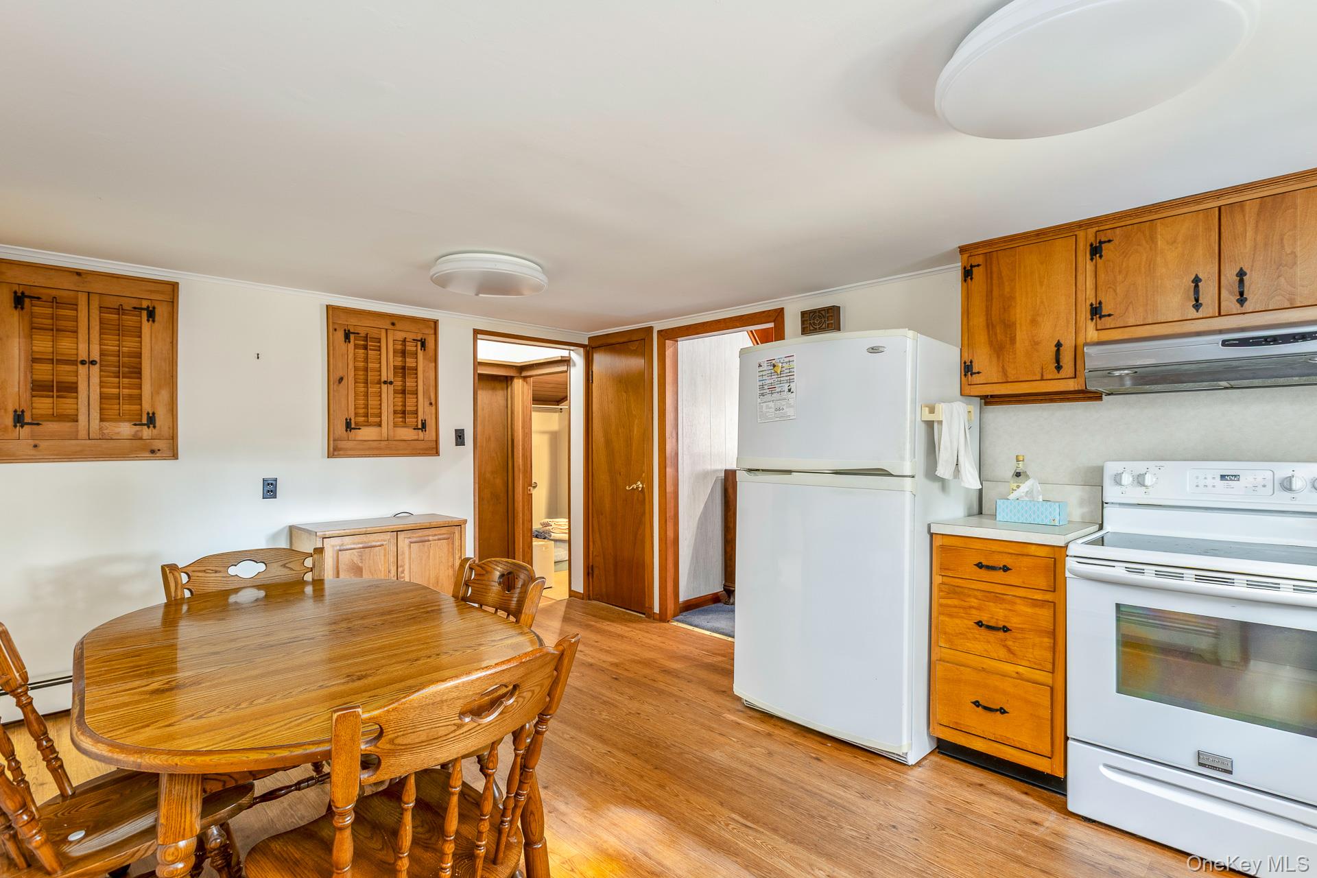 261 Elm Road West Mastic Beach, NY 11951 - Photo 7 of 22 a kitchen with stainless steel appliances granite countertop a refrigerator a stove a dining table and chairs with wooden floor