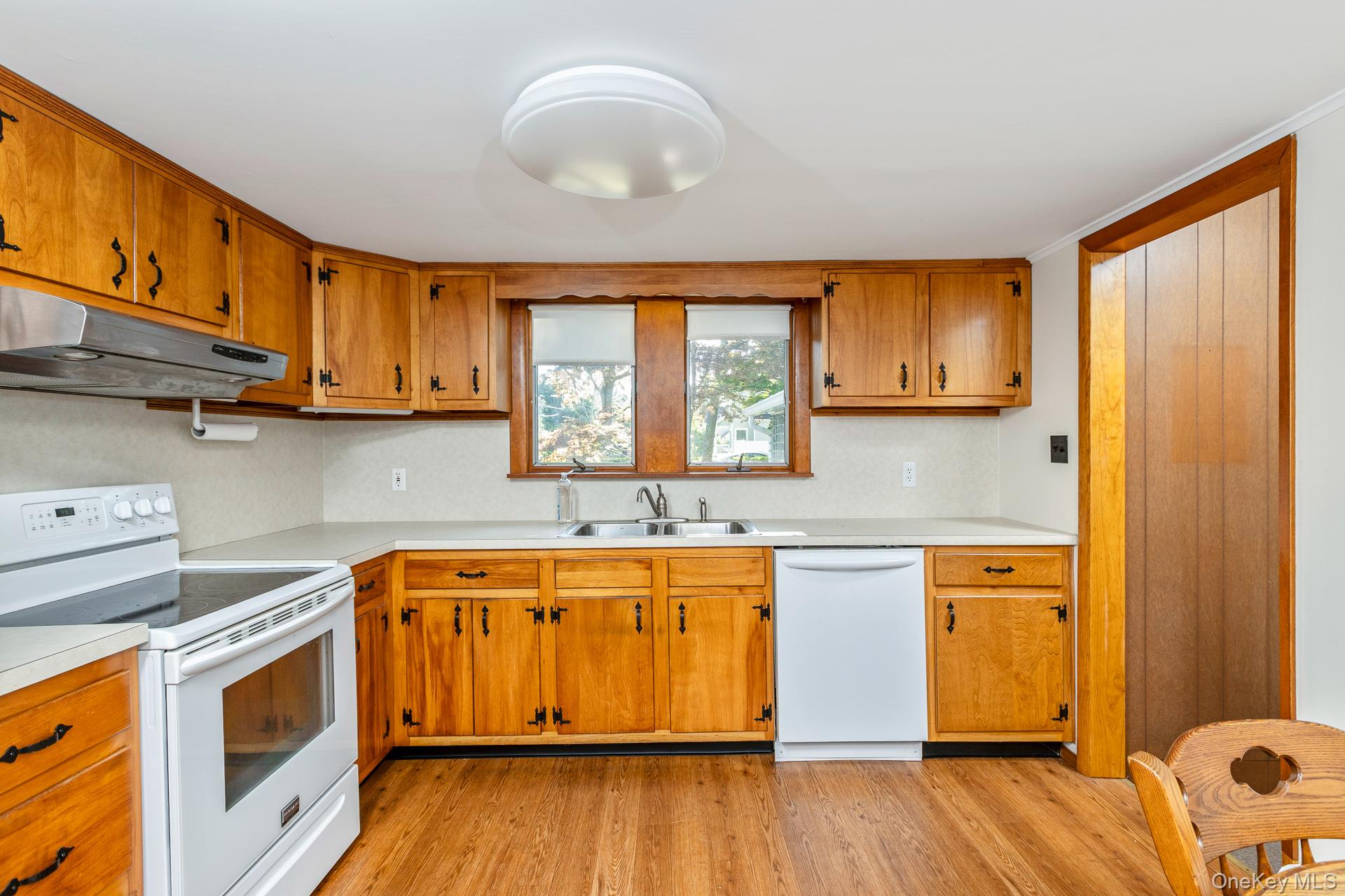 261 Elm Road West Mastic Beach, NY 11951 - Photo 8 of 22 a kitchen with stainless steel appliances granite countertop wooden cabinets a sink and dishwasher with wooden floor