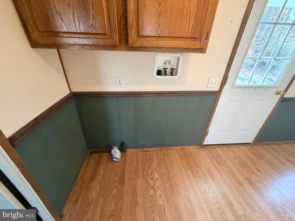 a view of a air conditioner and an empty room with wooden floor