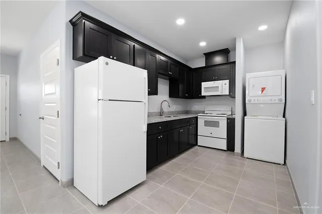 a kitchen with a refrigerator sink and cabinets