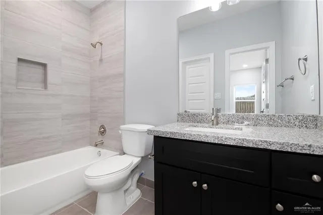 a bathroom with a granite countertop toilet a sink and a bathtub
