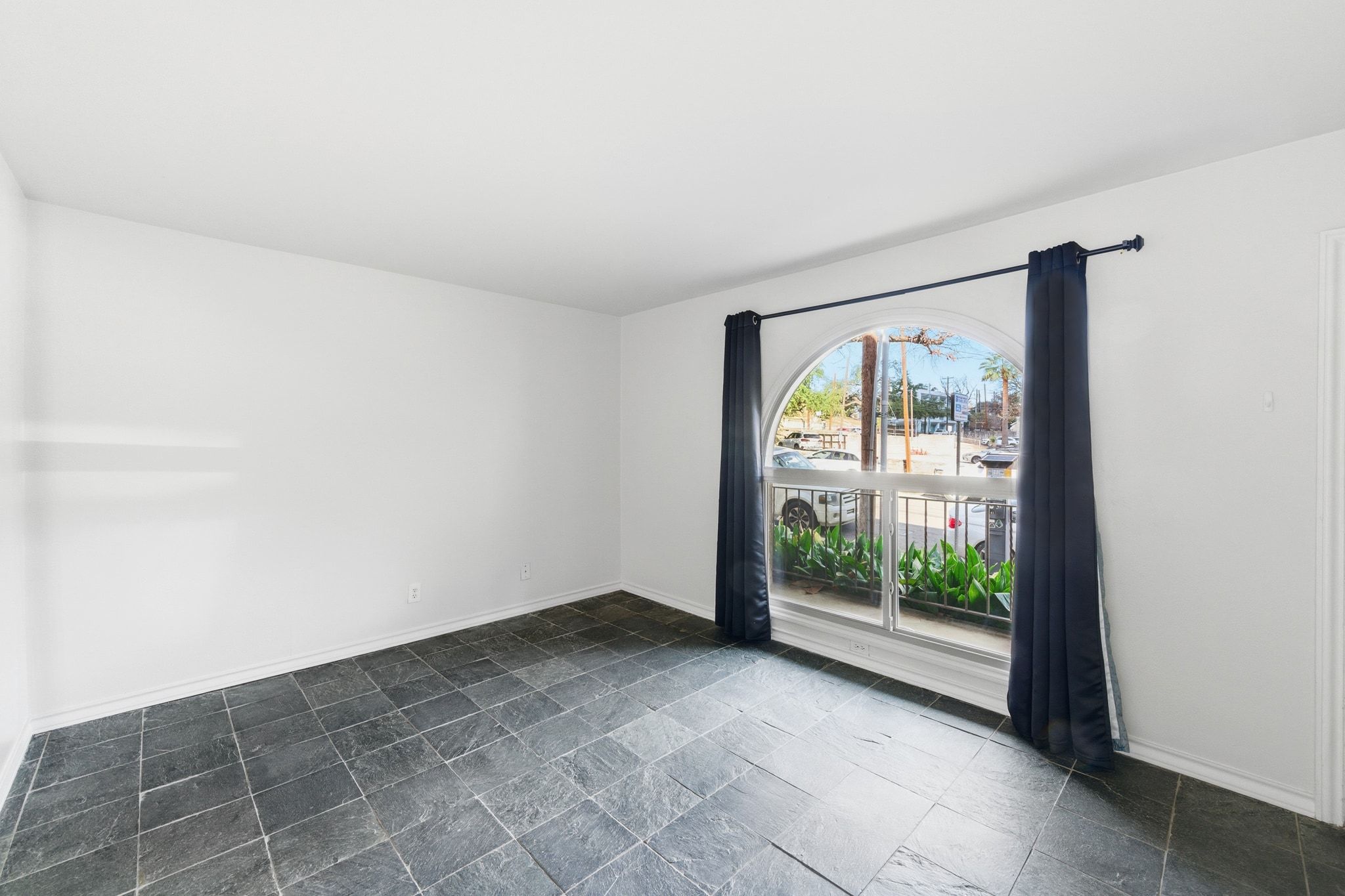 505 West 7th Street, Unit 106 Austin, TX 78701 - Photo 18 of 21 Empty room featuring baseboards and dark stone finish floors